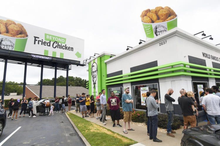 IMAGE DISTRIBUTED FOR BEYOND MEAT-  Consumers stand in line at an Atlanta-based KFC throughout the day to be among the first to try Beyond Fried Chicken, a plant-based chicken made in partnership with Beyond Meat, on Tuesday Aug. 27, 2019. (John Amis/AP Images for Beyond Meat)