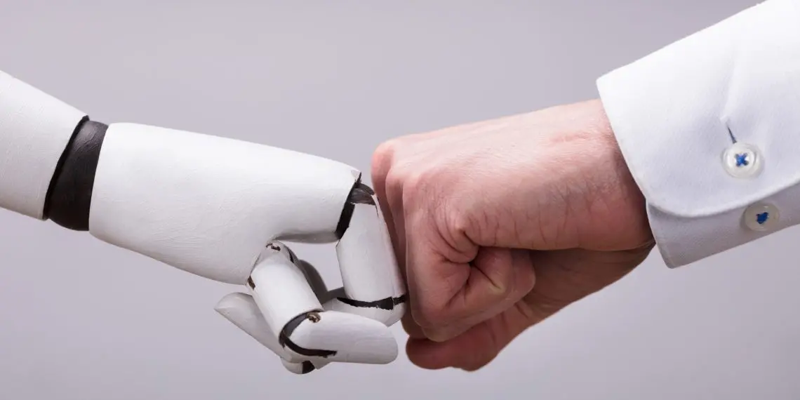 Robot y mano humana haciendo golpe de puño sobre fondo gris