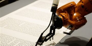 A robot writes a Torah at an installation in the Jewish Museum in Berlin, Germany, Thursday, July 10, 2014. It is an installation by the artist group robotolab. The robot is equipped with a pen nib and ink and will write the Torah in human speed. (AP Photo/Markus Schreiber)