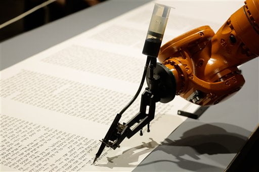 Робот пишет Тору на инсталляции в Еврейском музее в Берлине, Германия, в четверг, 10 июля 2014 г. Это инсталляция группы художников robotolab. Робот оснащен пером пера и чернилами и будет писать Тору с человеческой скоростью. (AP Photo / Маркус Шрайбер)