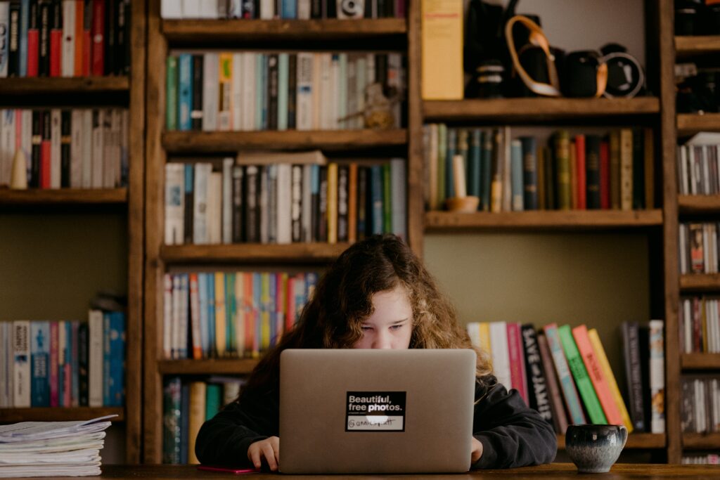 mulher em camisa preta de manga comprida usando macbook