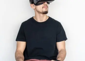 man sitting and using black virtual reality headset