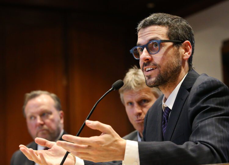 BOSTON MA. - MARCH 4:  Dr. Paul Biddinger, Vice Chair for Emergency Preparedness in the Dept. of Emergency Medicine at MGH and  Dr. Davidson Hamer, BU Professor of Global Health and Medicine, listen as  Dr. Michael Mina, Assistant Professor of Epidemiology and Assistant Professor in Immunology and Infectious Diseases at Harvard, speak before the Joint Committee on Public Health hearing to address the stateÕs continued preparedness for the coronavirus on March 4, 2020 in Boston, MA. (Staff Photo By Nancy Lane/MediaNews Group/Boston Herald)