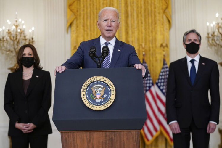 President Joe Biden speaks about the evacuation of American citizens, their families, SIV applicants and vulnerable Afghans in the East Room of the White House, Friday, Aug. 20, 2021, in Washington. Vice President Kamala Harris, left, and Secretary of State Antony Blinken listen. (AP Photo/Manuel Balce Ceneta)