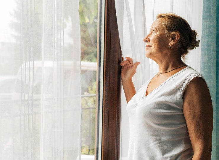 mujer mayor en casa con sol