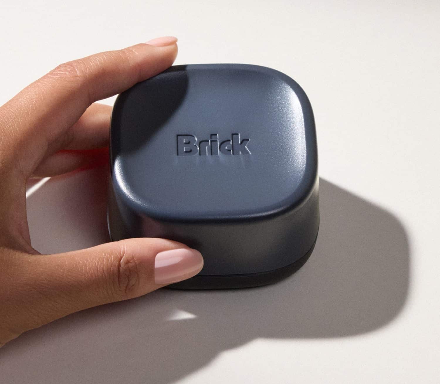 Una mano regge Brick Night, il dispositivo Bluetooth da comodino che blocca le app