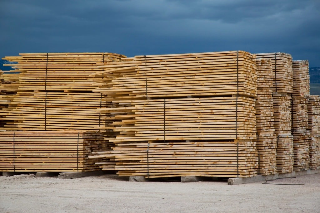 Cataste di tavole di legno in un piazzale, il materiale di partenza del legno trattato con l'acqua
