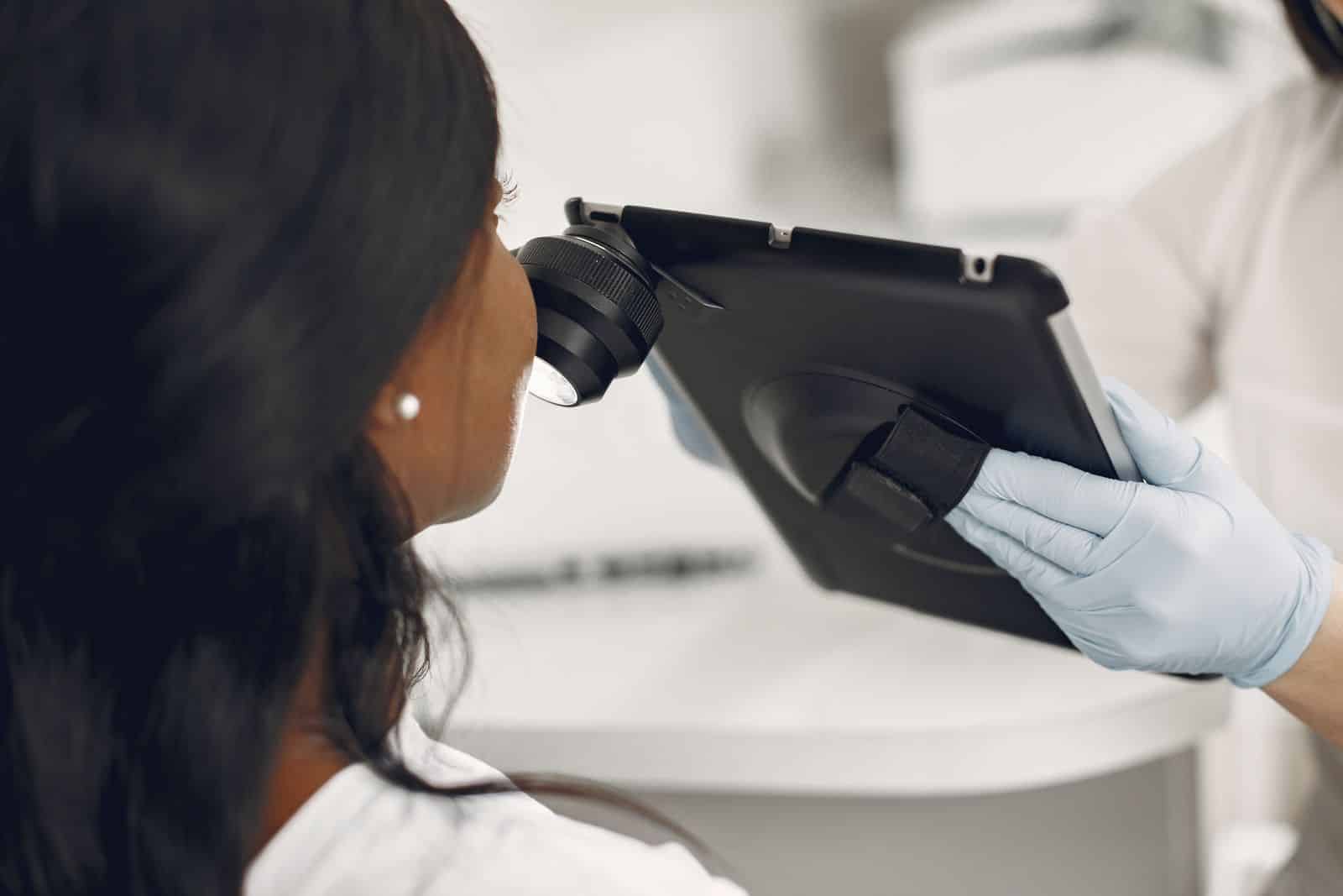 Dermatologo che controlla la pelle di una paziente con un dermatoscopio digitale, esame di controllo del melanoma