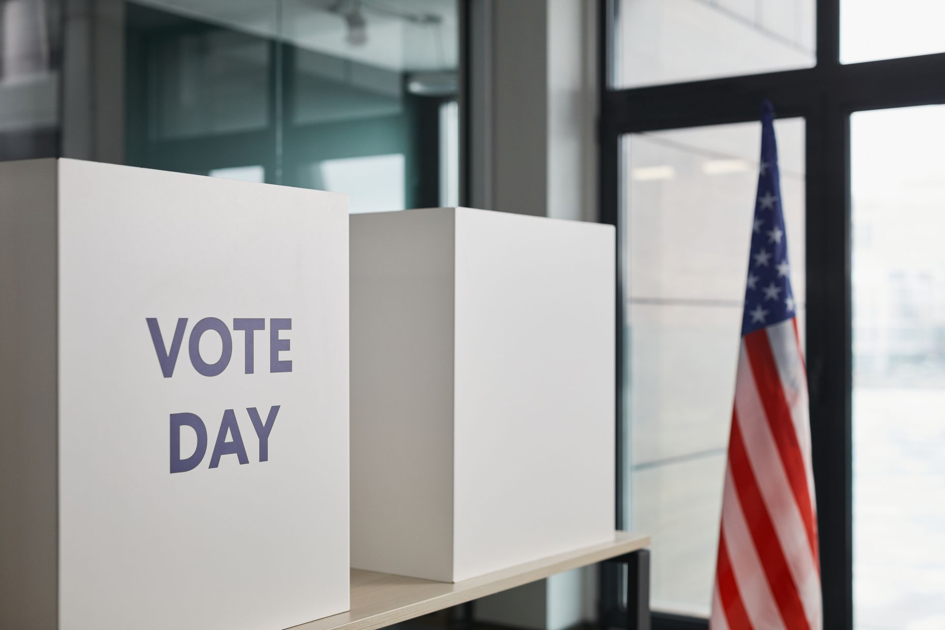 Cabina elettorale con bandiera americana, a richiamare l'ipotesi di MrBeast candidato alla Casa Bianca