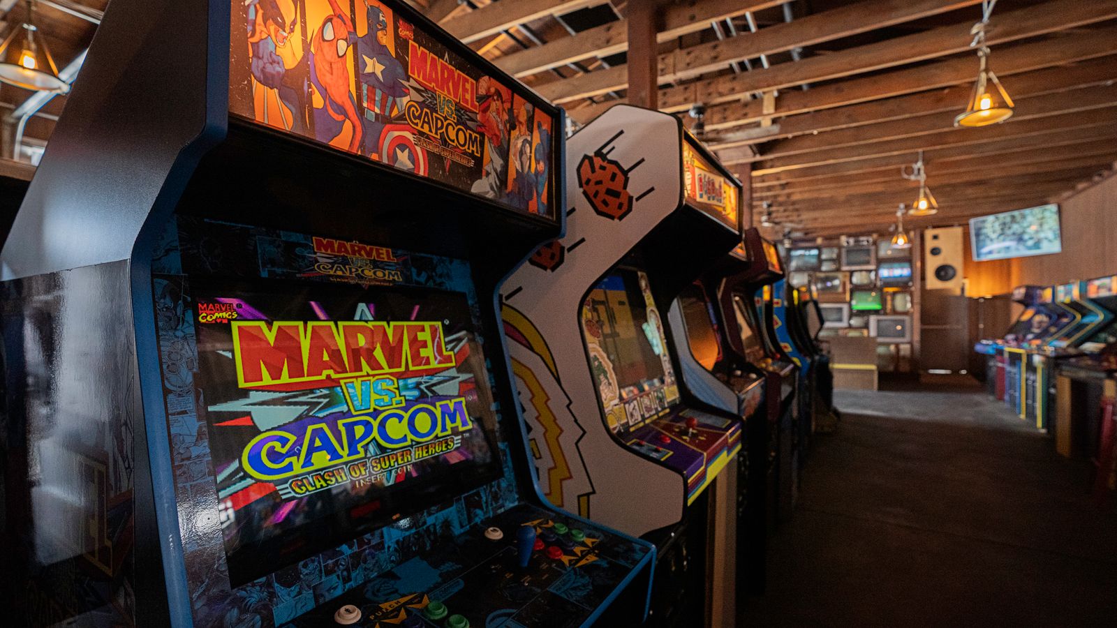 Cabinati in fila in una sala giochi, con Marvel vs. Capcom in primo piano