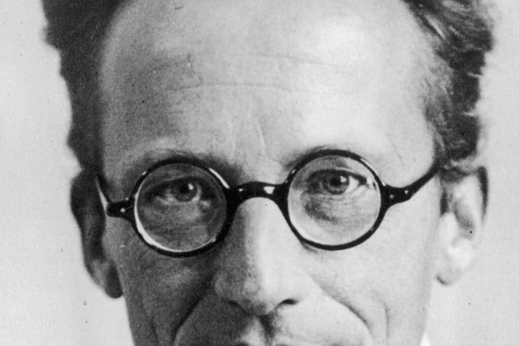 Il fisico Erwin Schrödinger in un ritratto in bianco e nero, con occhiali tondi